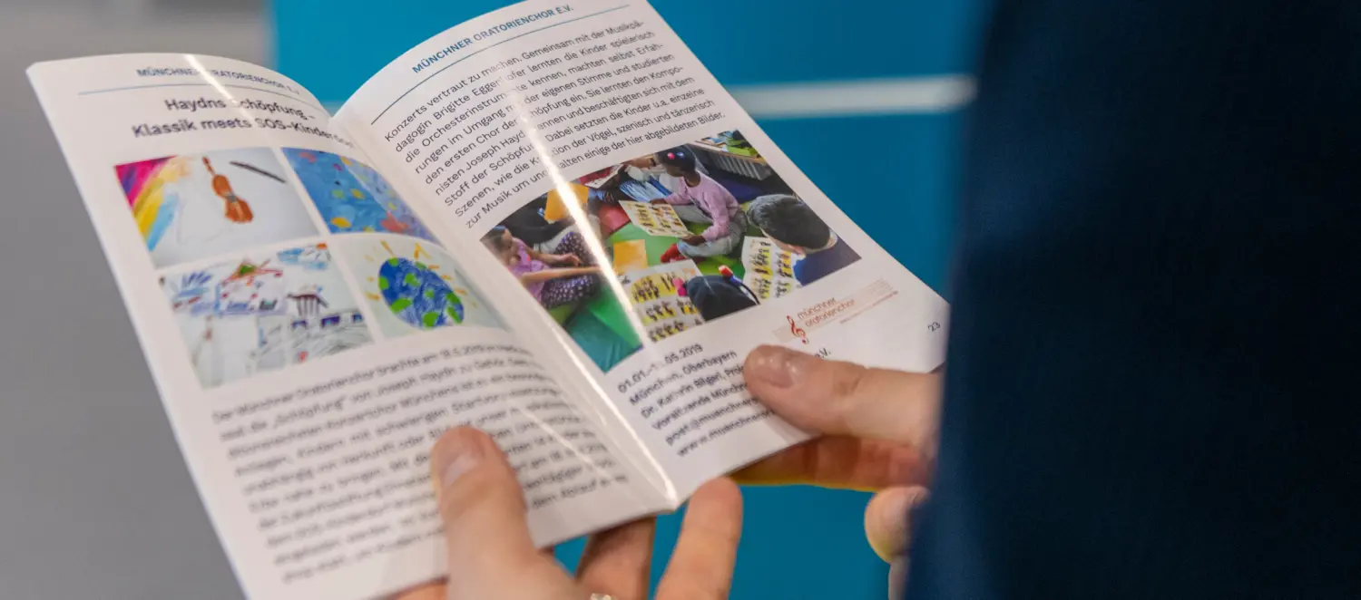 Schmuckbild: Frauenhände halte eine geöffnete Broschüre in der Hand
